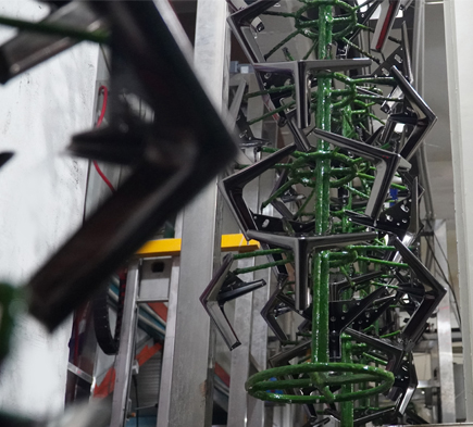Spray painting process for black sofa legs, showcasing DELTA CAINA's advanced surface finishing techniques for durable and stylish furniture hardware.